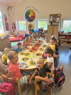 eine Gruppe von Kindern, die um einen Tisch sitzen